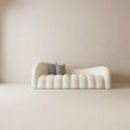 Modern white sofa with two gray cushions against a beige wall. Boucle salon furniture 