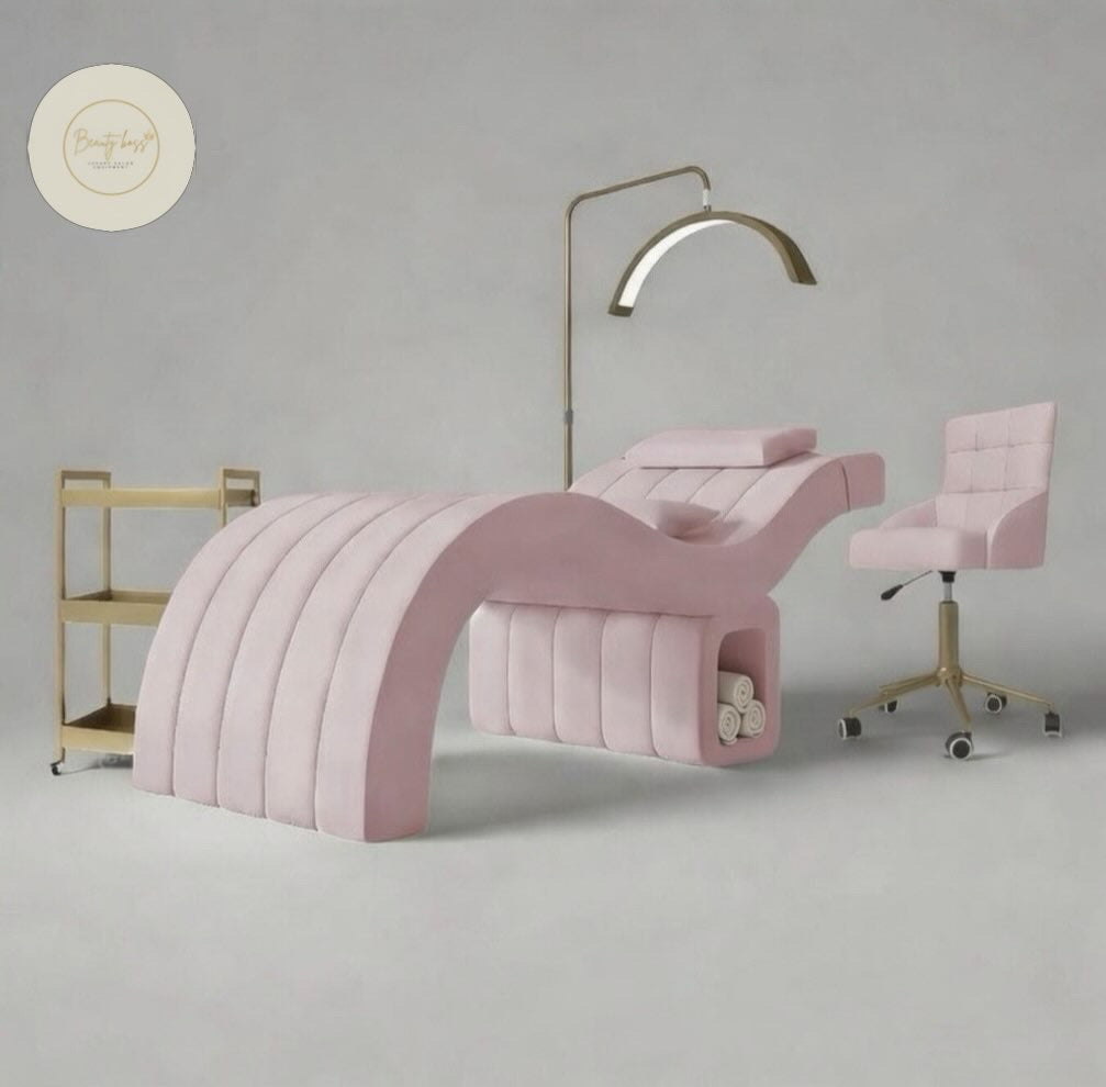 Pink nail salon chair and desk setup with gold accents on a gray background beauty bed